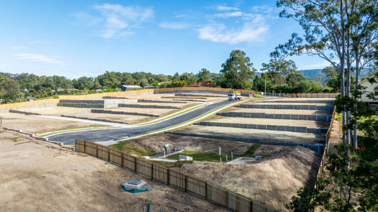 Aerial view of the completed residential subdivision at Gilston Road, Gold Coast, showcasing roadworks, underground services, and cleared development areas.