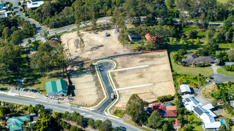 Aerial view of the completed residential subdivision at Gilston Road, Gold Coast, showcasing roadworks, underground services, and cleared development areas.