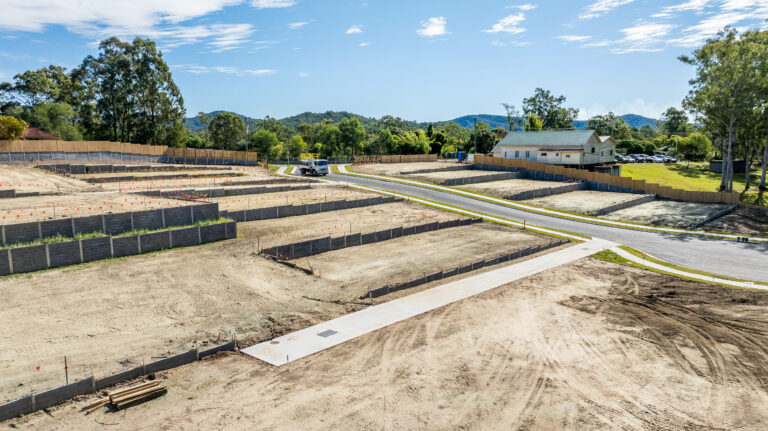 Aerial view of the completed residential subdivision at Gilston Road, Gold Coast, showcasing roadworks, underground services, and cleared development areas.